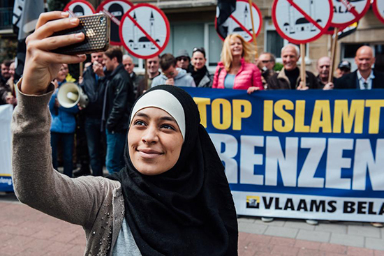 Une jeune musulmane se prend en selfie devant une manifestation islamophobe