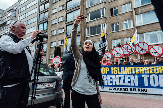 Une jeune musulmane se prend en selfie devant une manifestation islamophobe