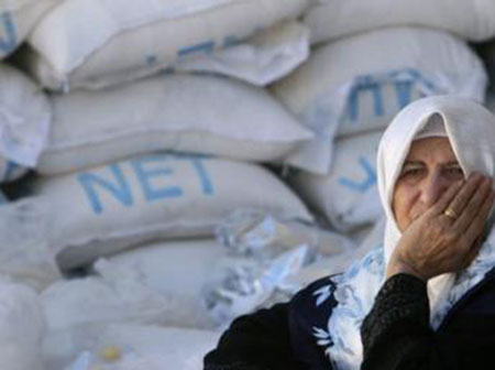 Une femme palestinienne attend les aides humanitaires au quartier général de l'UNRWA à Gaza